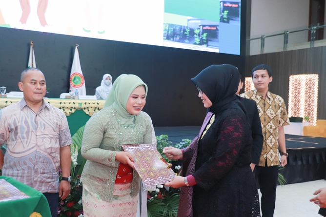 Penyerahan penghargaan oleh Dekan Fikes Dr. Retno Widowati, M.Si. (kebaya hitam) kepada mahasiswa terbaik dari profesi Ners (kebaya hijau)