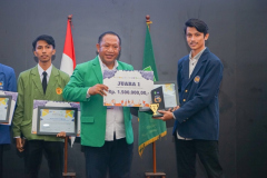 Pemberian hadiah oleh Kepala Biro Administrasi Kemahasiswaan Unas Kamaruddin Salim, S.Sos.,M.Si. (almamater hijau) kepada pemenang lomba LKTI (almamater biru dongker)