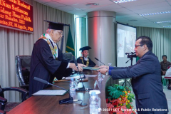 Penyerahan surat keputusan kelulusan oleh Promotor Prof. Umar Basalim, DES. (kiri) kepada Dr. Heru Dian Setiawan, S.T., M.Si. (kanan)