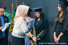 Pemasangan selempang oleh  Dekan Fisip Dr. Erna Ermawati Chotim, S.Sos., M.Si. (kiri) kepada lulusan terbaik dari Program studi Sosiologi Mojang Ayu Febriyanti (kanan)