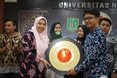 Wakil Dekan Fakultas Hukum Ummu Salamah, S.Ag., M.A. (kiri) memberikan piala bergilir kepada pemenang moot court (kanan)