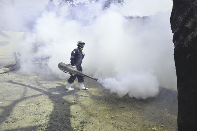 Proses pengasapan fogging di area sekolah pascasarjana Universitas Nasional