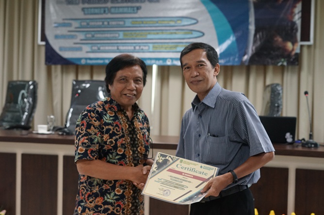 Ketua Program Studi Magister Biologi Dr. Tatang Mitra Setia, M.Si. (kanan) memberikan sertifikat kepada Moderator Dr. Sugardjito (kiri) pada acara The Public Lecture on “Borneo Mammals” di Ruang Seminar lantai 3 menara 1 UNAS, Senin (16/9)