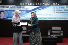 Moderator  Evi Jovita S.Hum., M.A. menerima cinderamata yang diberikan oleh Dosen fakultas bahasa dan sastra Siti Tuti Alawiyah S.S., M.Hum. pada acara public lecture di aula blok 1 lantai 4 UNAS, Kamis (16/5)