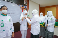 Prosesi penyematan name tag kepada perwakilan mahasiswi pendidikan profesi bidan oleh Dekan Fakultas Ilmu Kesehatan Universitas Nasional Dr. Retno Widowati, M.Si.