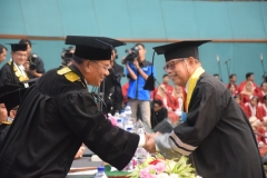 rektor unas berjabat tangan dengan wisudawan