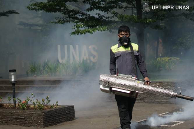 Petugas melakukan fogging di lingkungan universitas nasional sebagai upaya pencegahan Virus Coran dan demam berdarah pada Sabtu (21/3)