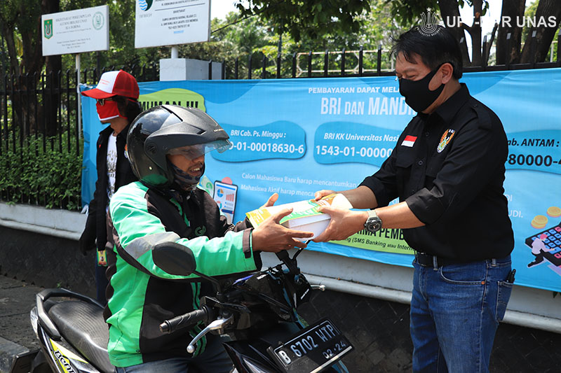 Ketua Umum UNBC yang juga Kepala Biro Administrasi Umum Universitas Nasional Drs. Ian Zulfikar, M.Si. memberikan bantuan makanan kepada driver online di kampus Unas Pejaten, Rabu 22 April 2020