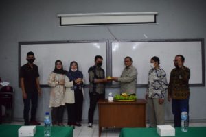 Dr. Suryono Efendi, S.E., M.B.A., M.M., (kanan) memberikan potongan nasi tumpeng.